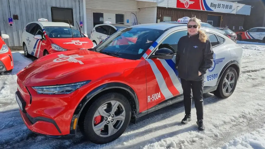 Taxi 1-sjåfør ved bilen på vinterføre